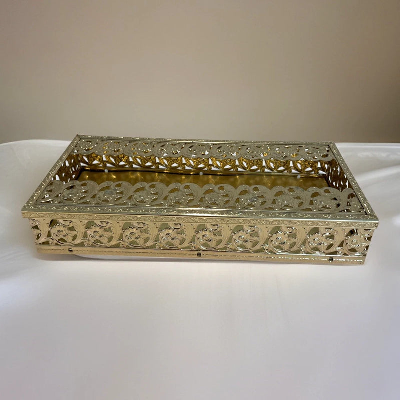 Gold tone filigree tissue box holder, rectangular with raised floral cutout frame.