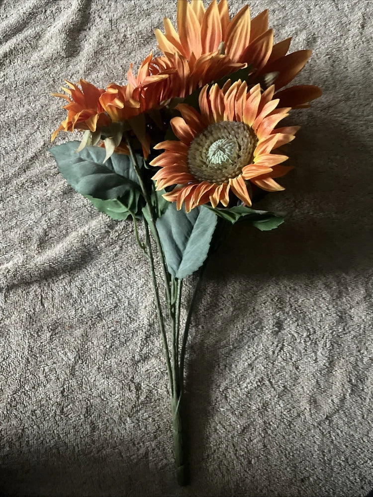 Orange sunflower bush stick with two blossoms, dark centers, and green leaves