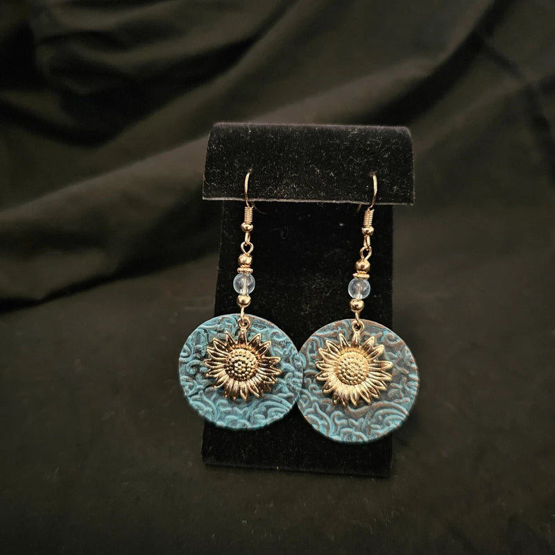Sunflower drop earrings with blue textured discs and gold-tone hooks