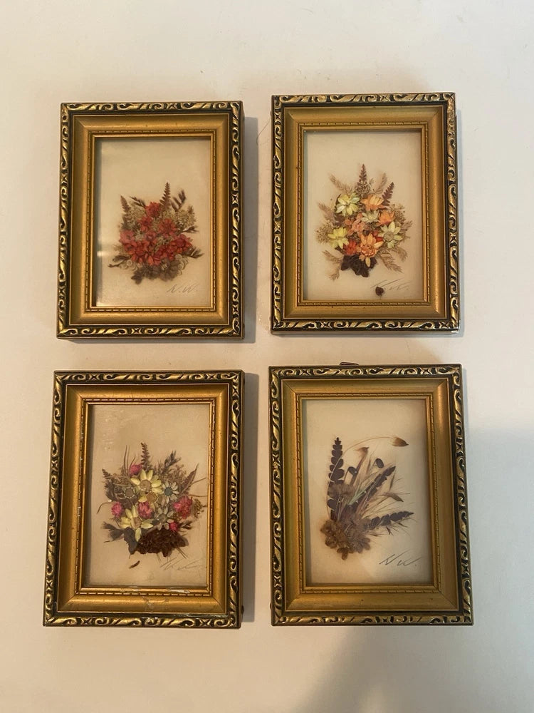 Set of 4 framed pressed flower wall art with small botanical arrangements in ornate gold frames