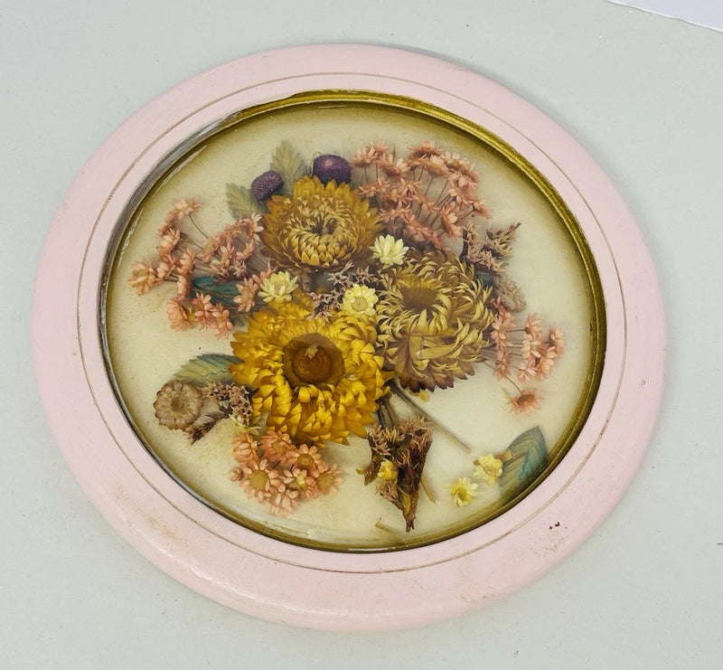 Round convex glass dried flower art with yellow, purple, and pink blooms in gold frame