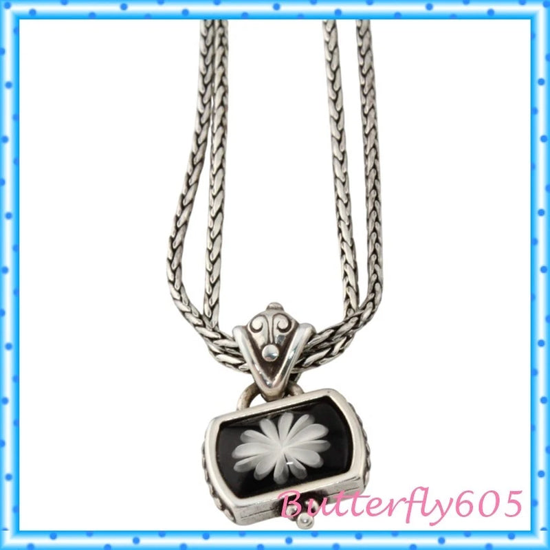 Silver chain pendant necklace with black rectangular pendant and white flower