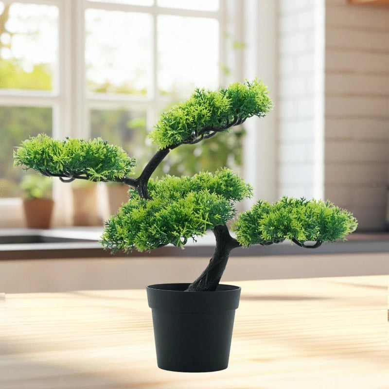 Artificial bonsai tree with bright green foliage and black trunk in black pot