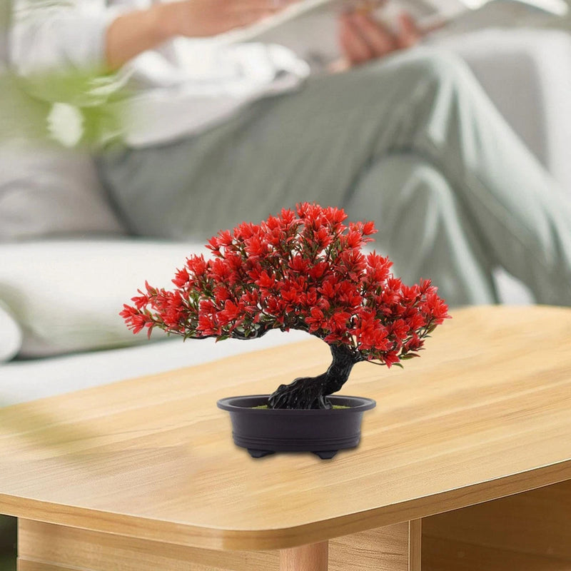 Small artificial bonsai tree with red clustered flowers in dark round pot