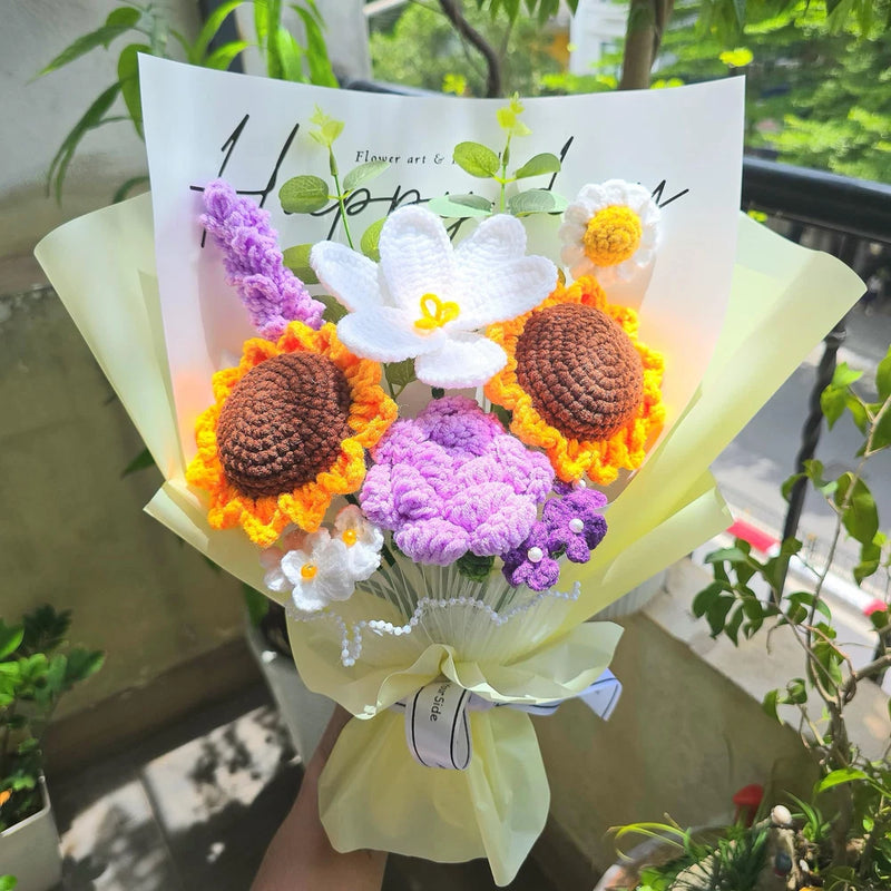 Crochet flower bouquet with white blooms, orange and purple knitted flowers, wrapped in pale green