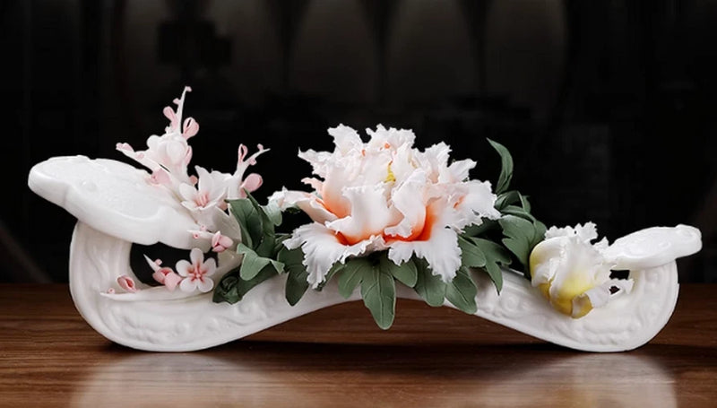White porcelain ruyi statue with peony flowers and green leaves