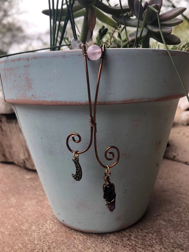 Metal pot hugger with crystal bead and curled hooks for securing a garden pot