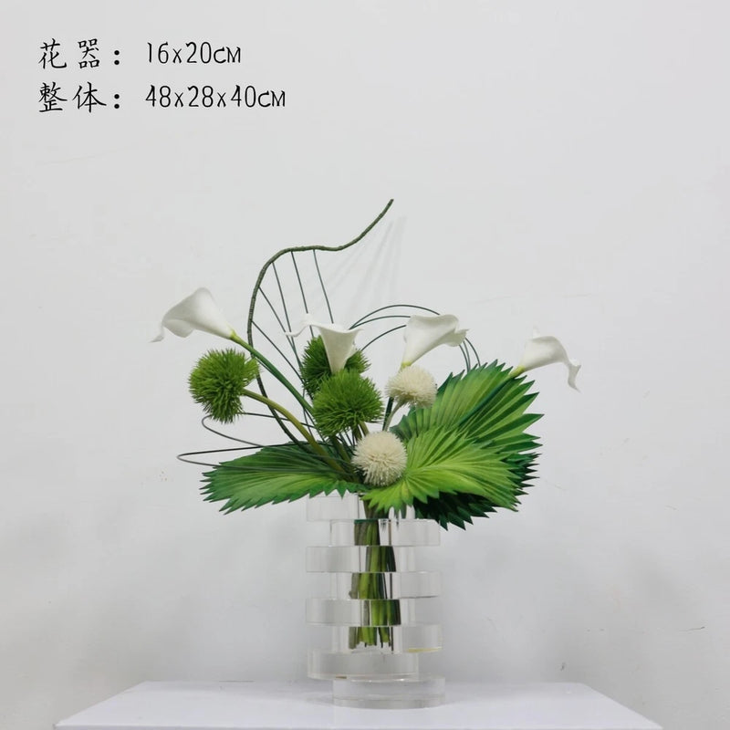 Artificial potted plant ornament in clear vase with green leaves and white flowers