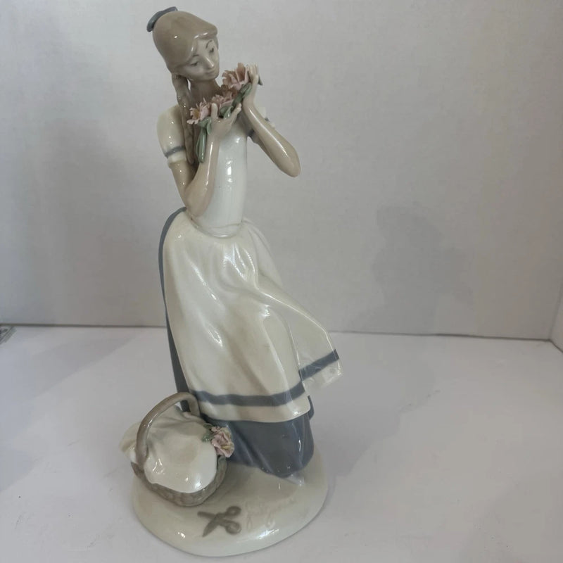 Porcelain maiden figurine holding carnations, white and blue dress with flower detail