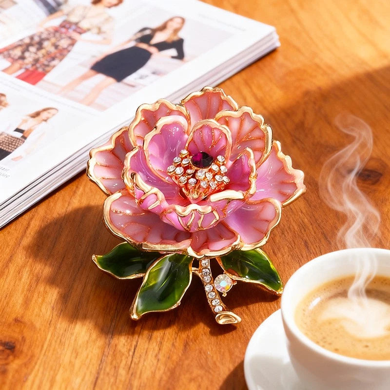 Pink peony flower brooch with gold-tone frame, rhinestone center and green leaves