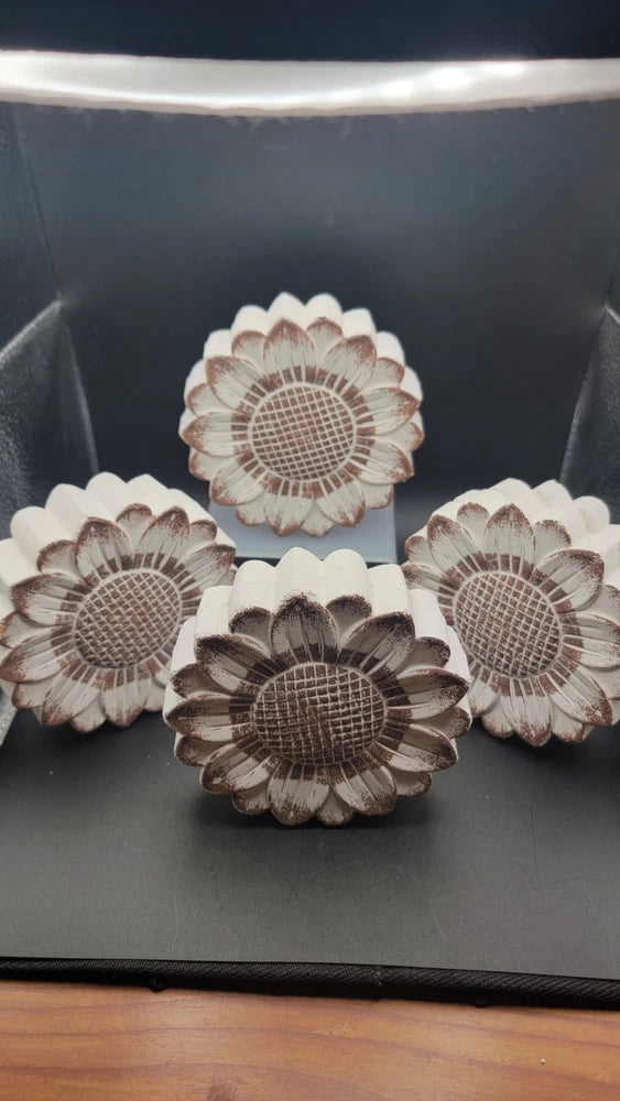 Set of four round floral plaques with layered petals and dark circular centers