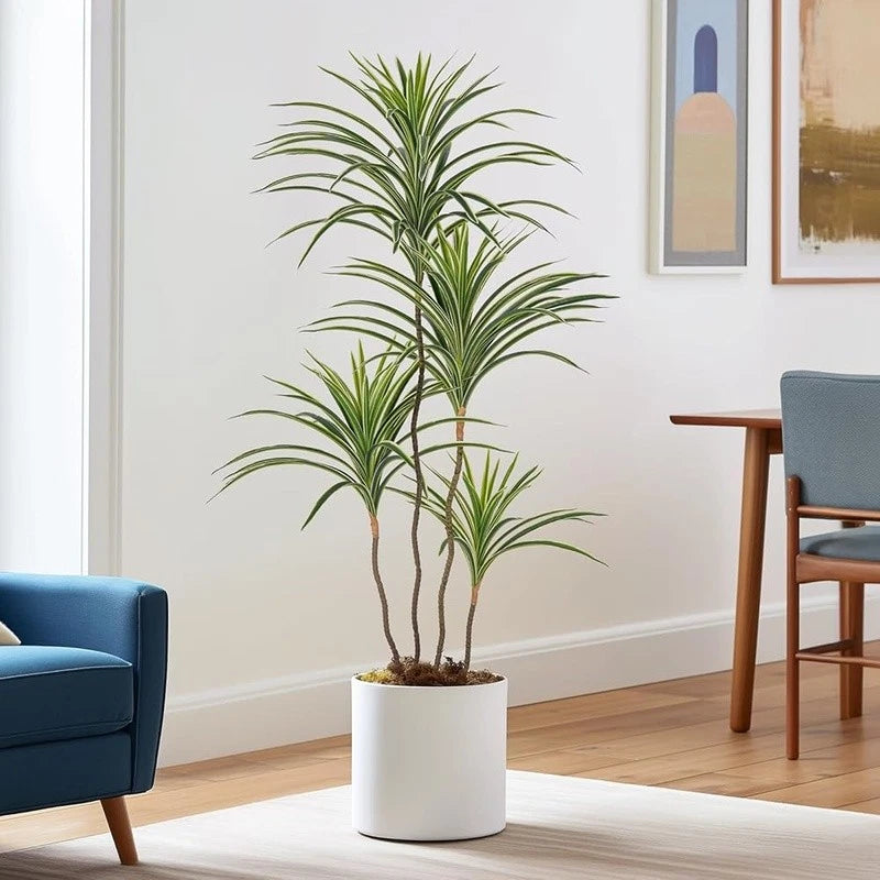 Faux dracaena plant with slender green leaves in a white pot
