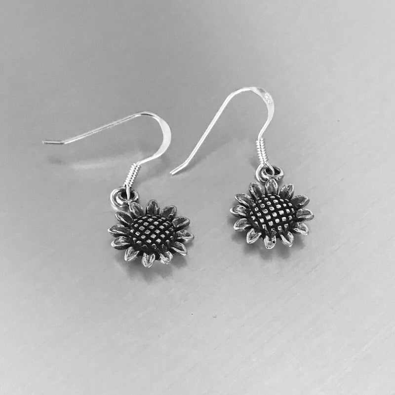 Silver sunflower drop earrings with textured petals and dark enamel center