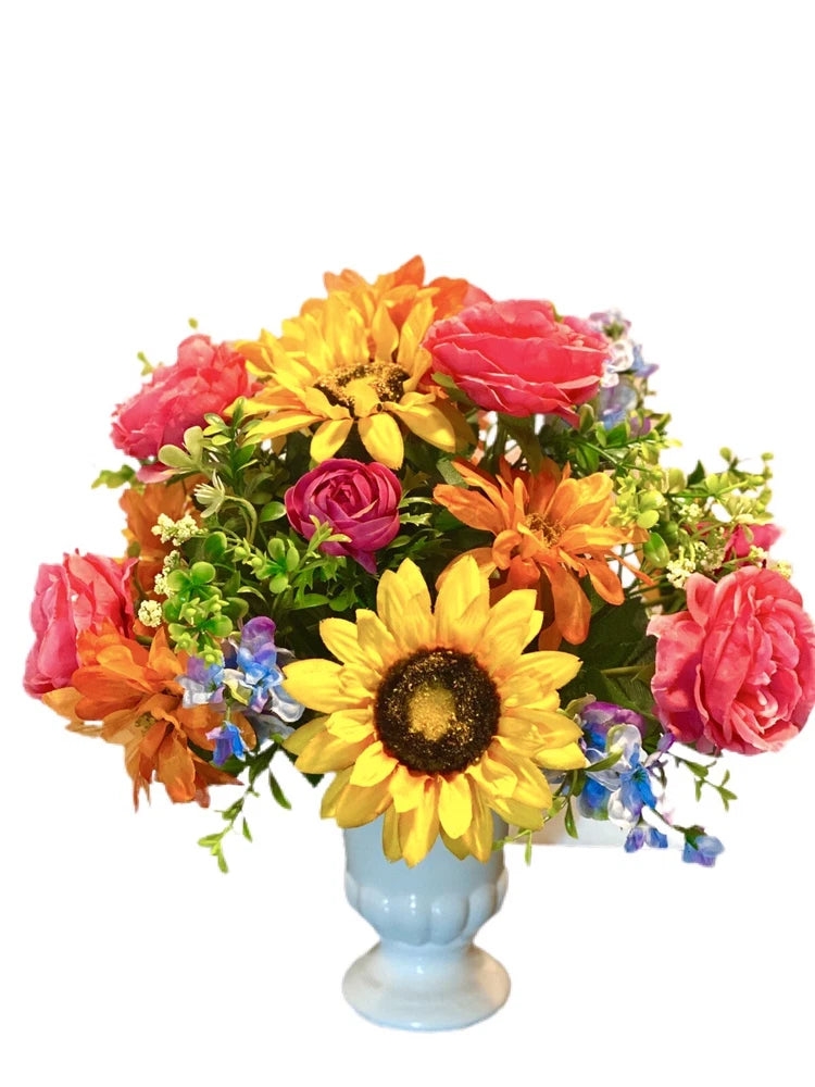 Colorful flower arrangement in a light blue vase with sunflower and mixed roses