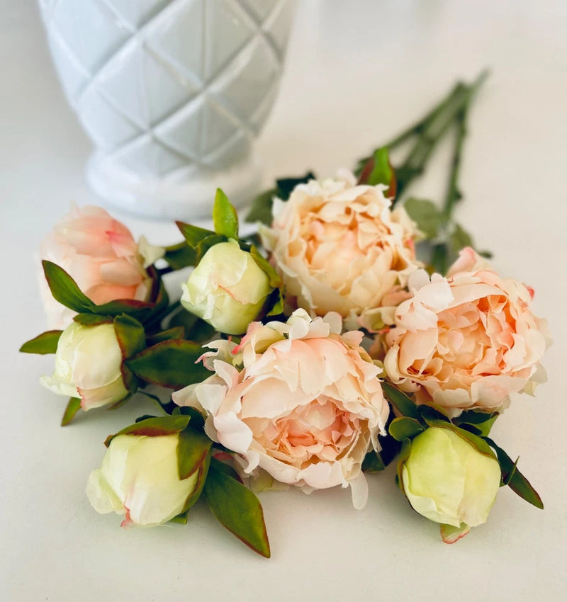 Long faux peony stem with cream, blush, and peach flowers and green leaves