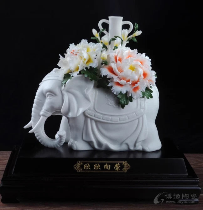 White porcelain elephant statue with peony flower bouquet on decorative base