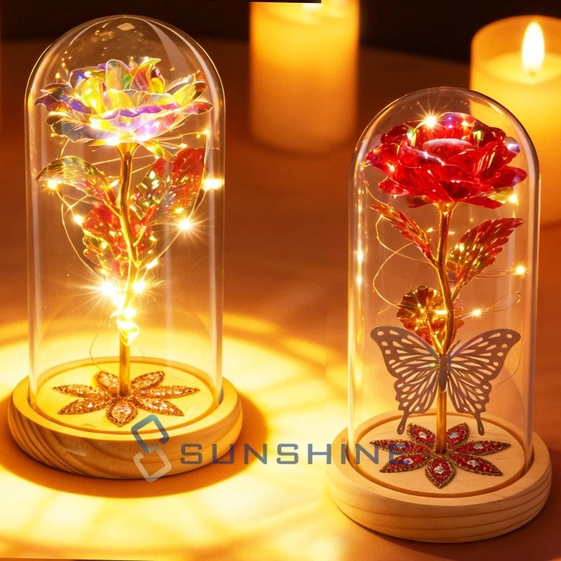 Glowing rose in clear glass dome with gold base and butterfly decoration
