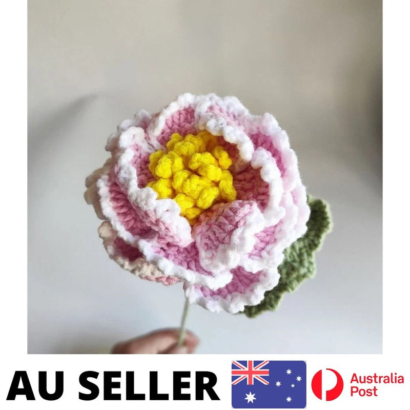 Handmade crochet peony flower with yellow center, pink petals, and green leaf