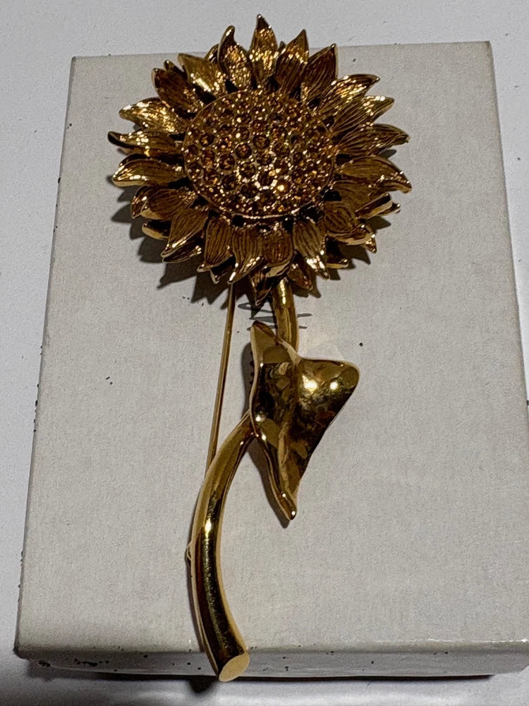 Gold-plated sunflower brooch with orange crystal center and leaf accents