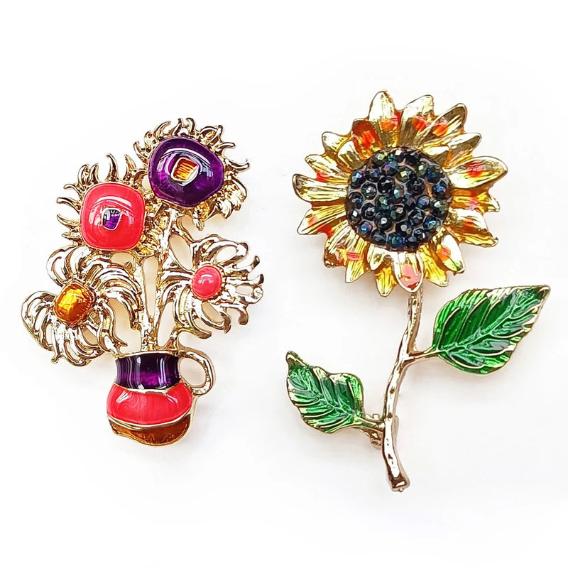 Gold-tone sunflower brooch with orange petals, dark center, green leaves