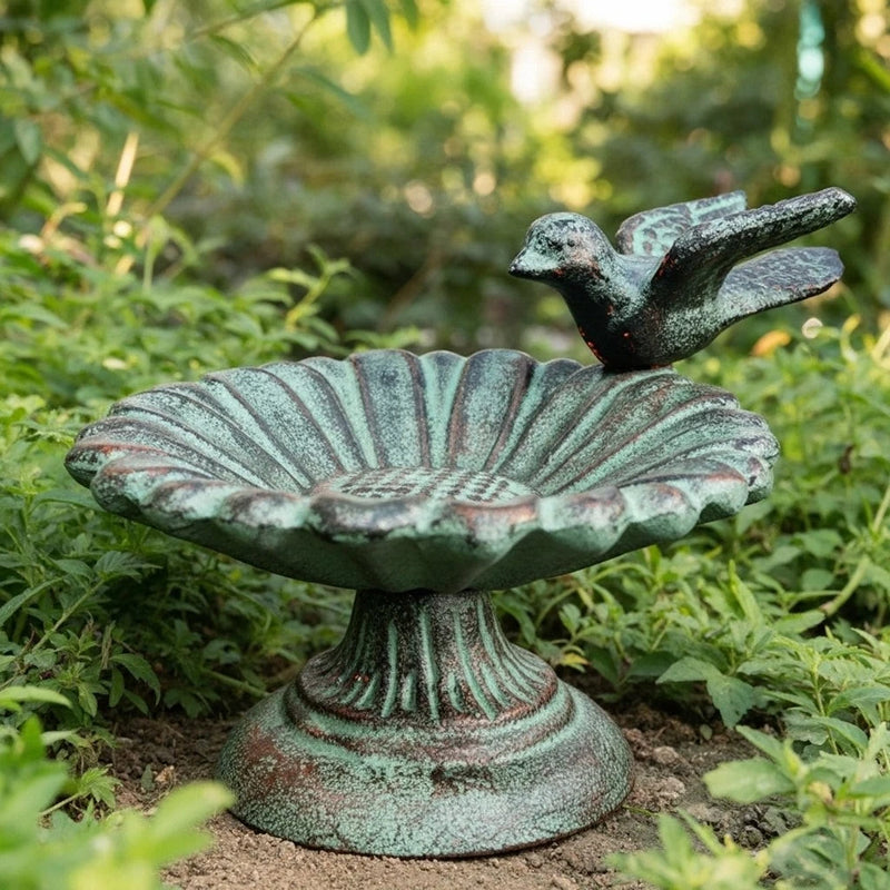 Verdigris cast-iron bird bath with pedestal and sunflower motif, with bird figure