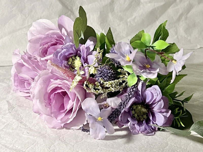 Artificial rose bouquet with purple and lilac flowers, green leaves