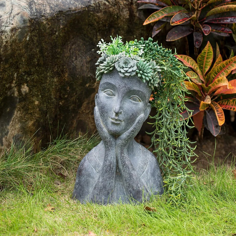 Gray face-shaped planter pot with drainage, filled with green succulents