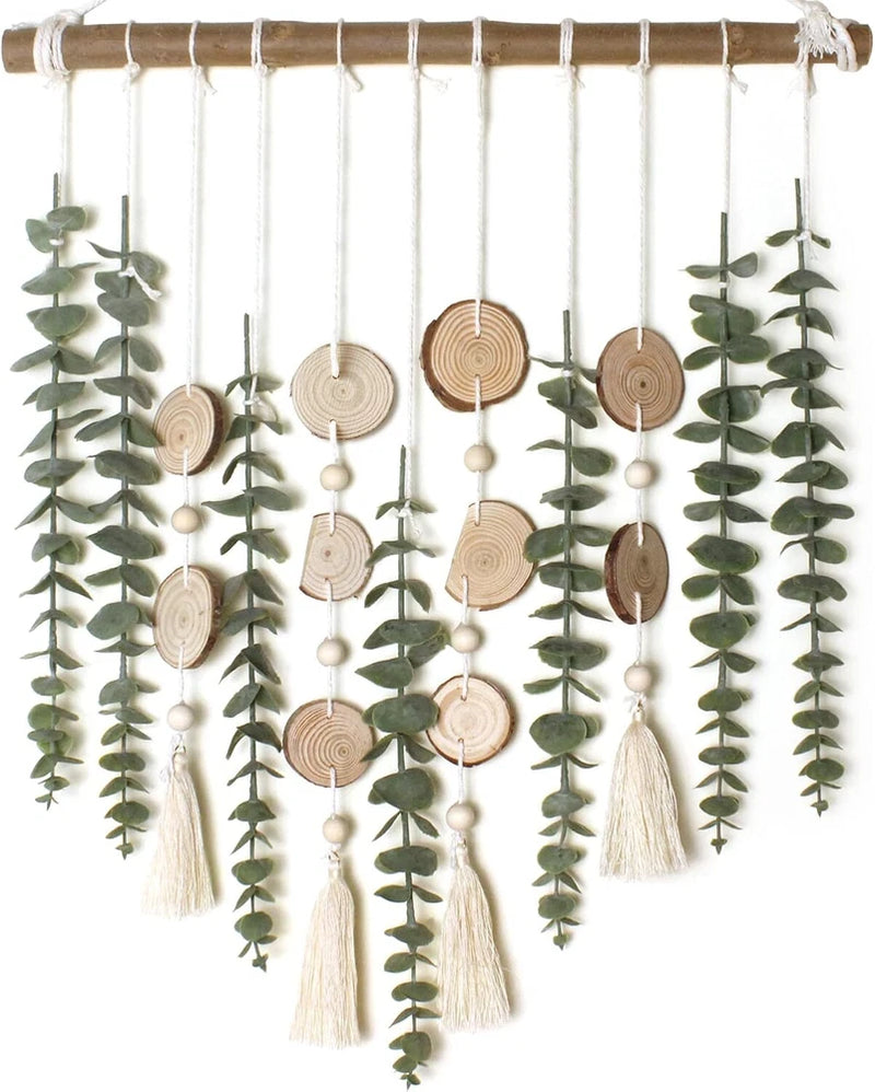 Artificial eucalyptus wall hanging with green sprigs, wooden discs, and tassels