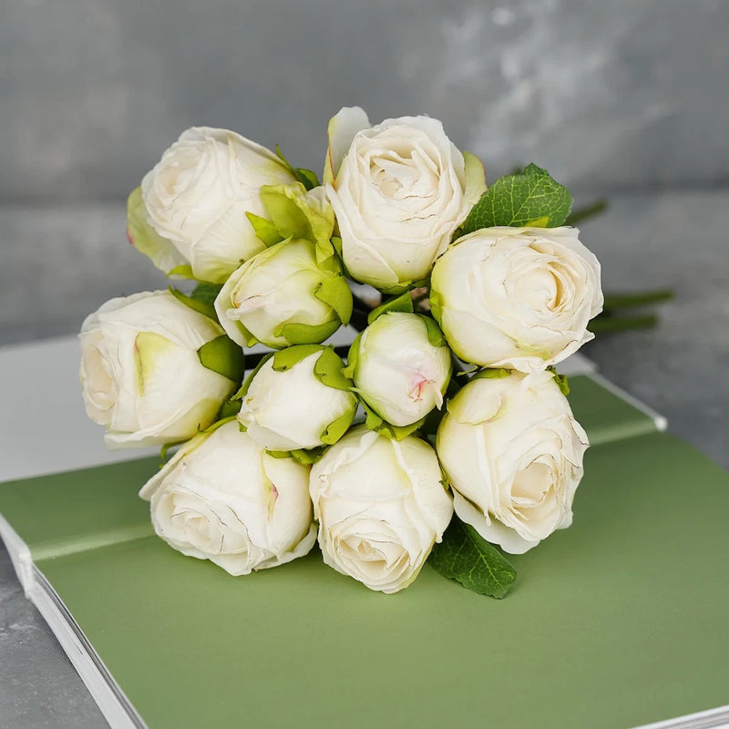 White dried-look rose bouquet with 10 stems, cream roses, and green leaves