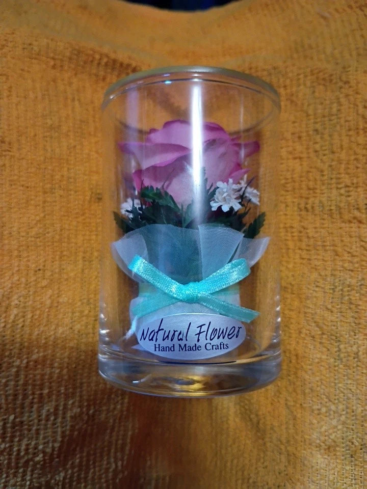 Sealed glass flower dome with purple and white preserved flowers, teal ribbon tie