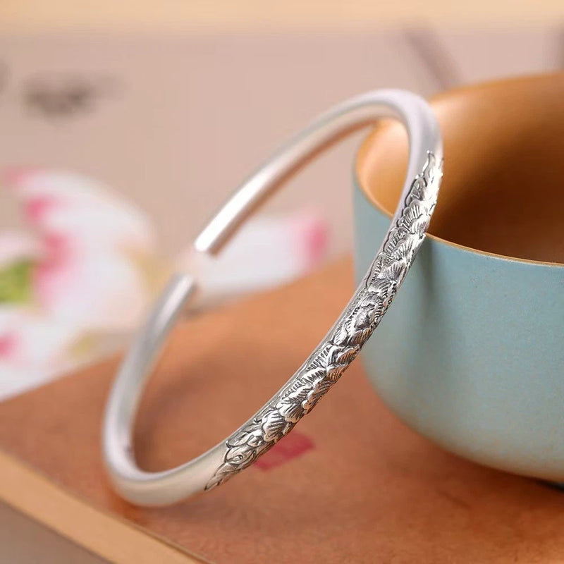 Fine silver open bangle bracelet with engraved peony-style floral pattern