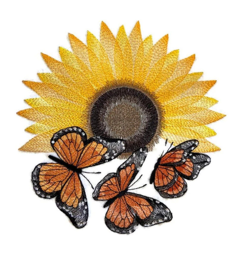Embroidered sunflower with orange monarch-style butterflies and dark centers on white backing