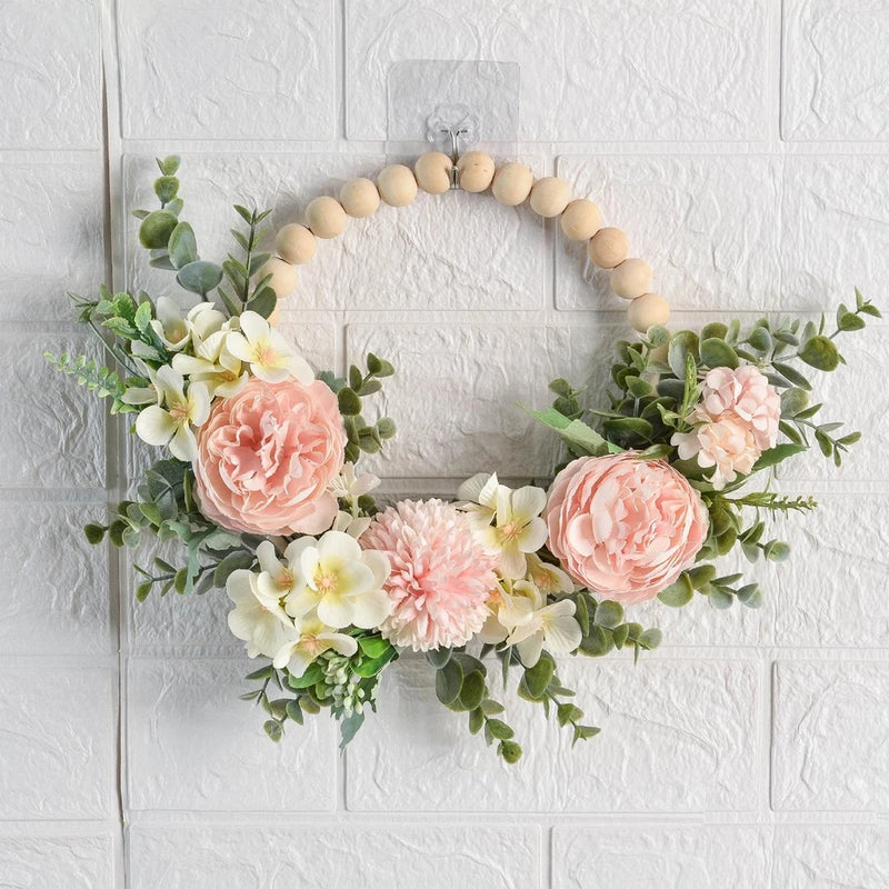 Wooden bead floral wreath with blush and cream peony-style flowers and green leaves