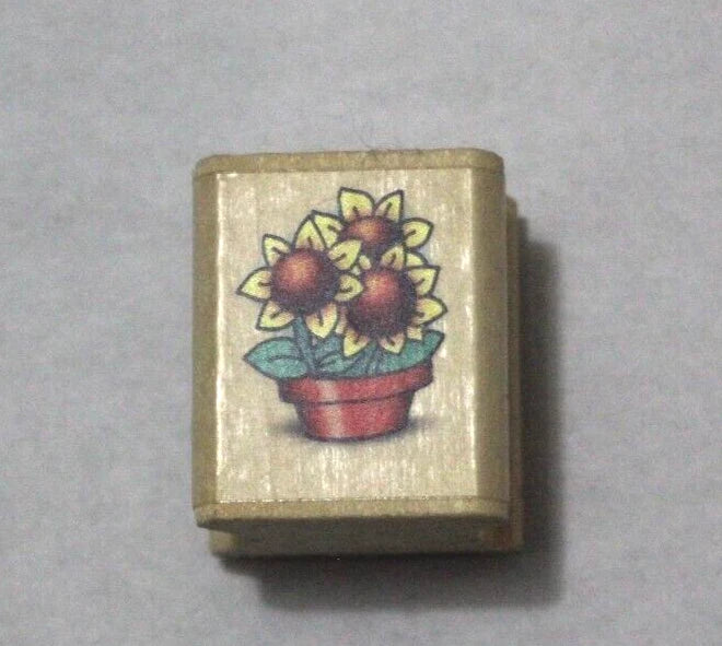 Sunflower pot rubber stamp with colorful flower and leaf design on a beige block