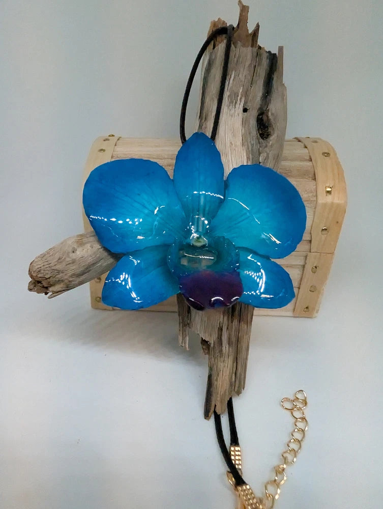 Blue resin orchid pendant on faux leather black cord with gold chain detail