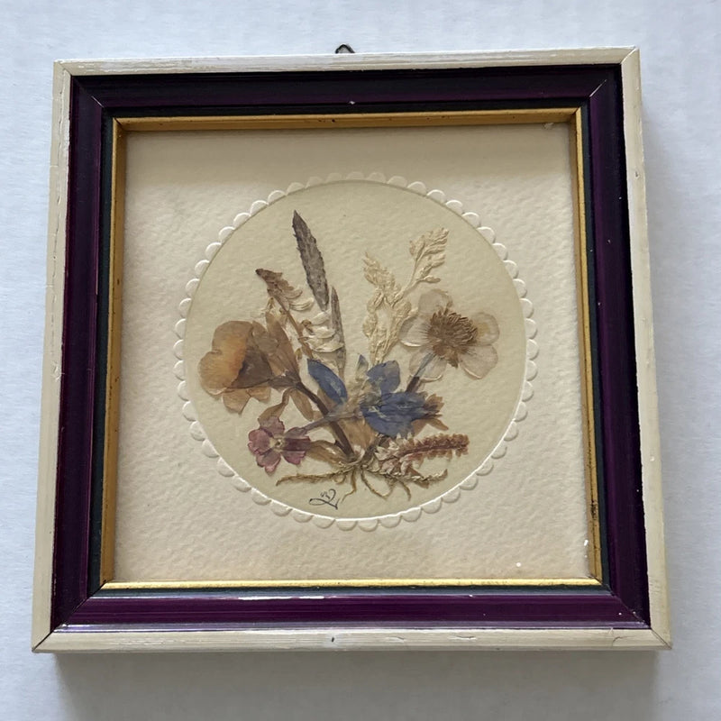 Framed dried pressed flower wall hanging with oval floral arrangement and dark purple frame