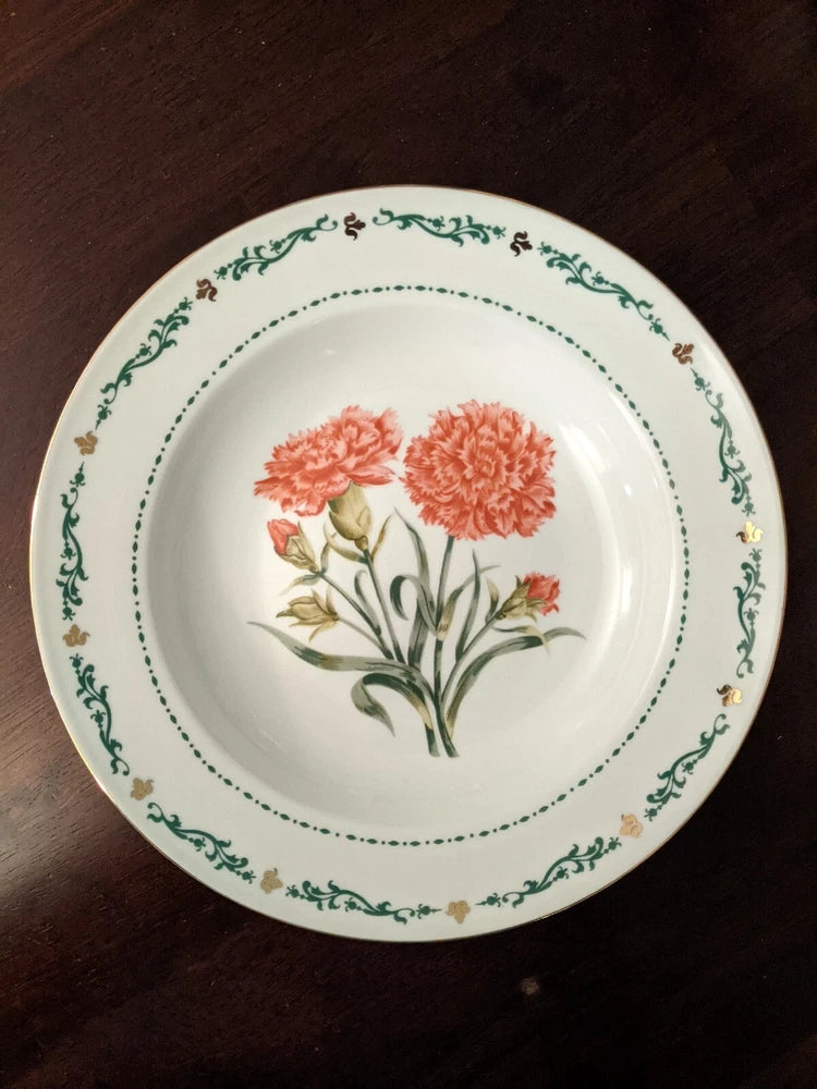 White soup bowl with green rim and orange carnation flower illustration