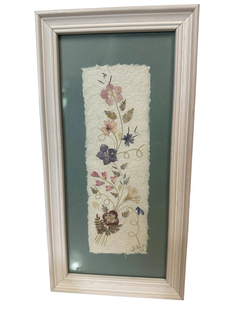Light wood framed pressed dried flower artwork with botanical blooms on cream paper