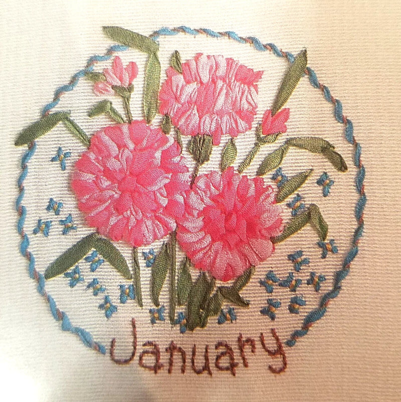 Embroidered ribbon carnation flower patch with blue border and 'January' text