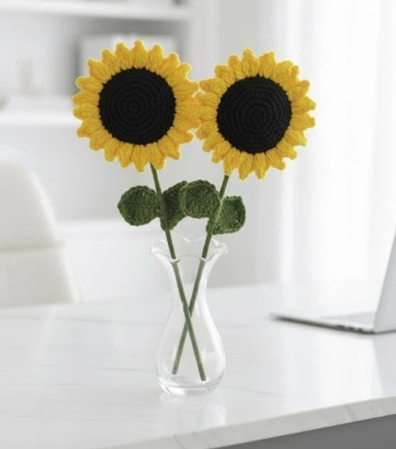 Crocheted sunflower knit flower arrangement with two yellow blooms in a clear glass vase