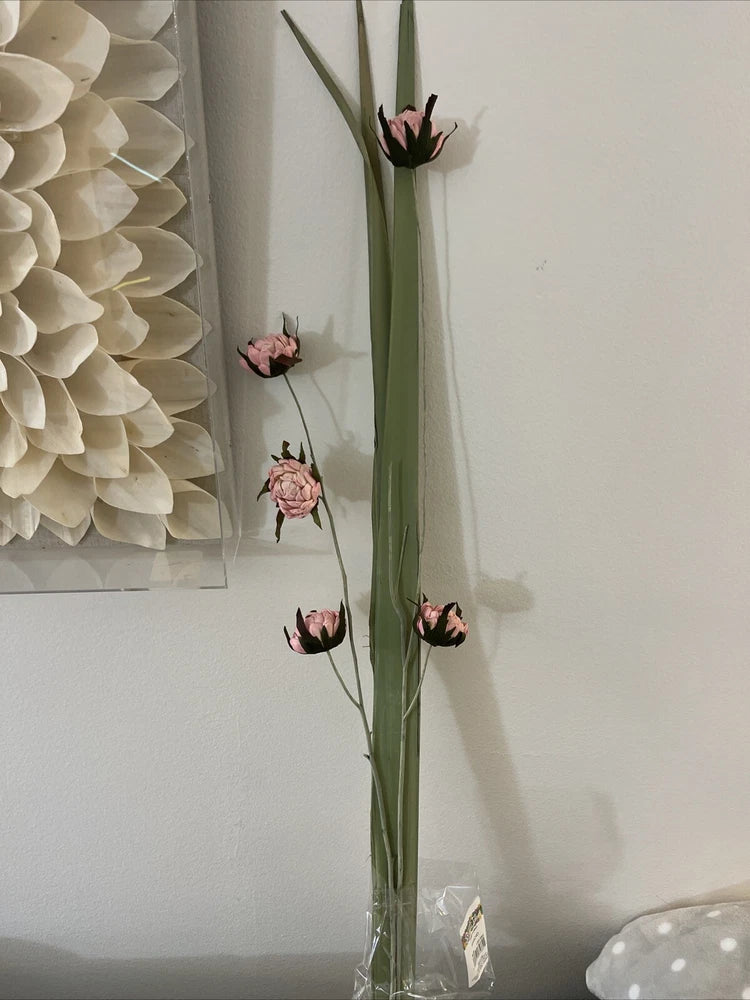 Dried floral branch with long green stem and small pink and dark dried blooms