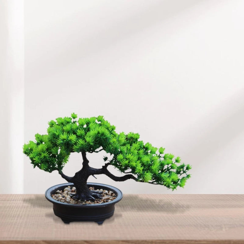 Artificial bonsai tree with bright green leaves in dark pot with decorative stones
