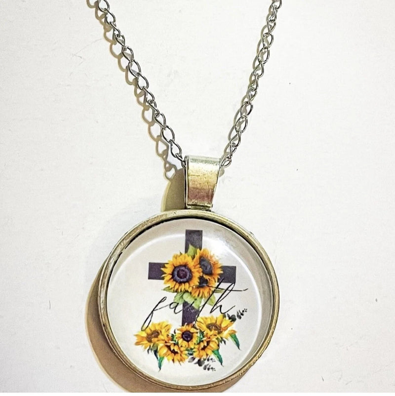 Silver-tone round sunflower pendant with cross and bouquet, on a chain necklace