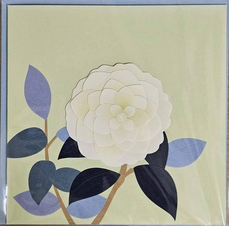 Blank greeting card front with white 3D flower and dark blue leaf accents